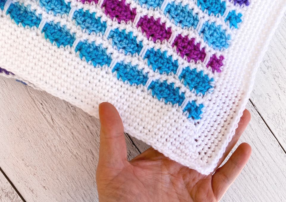 hand showing the corner of the ice cream yarn baby blanket